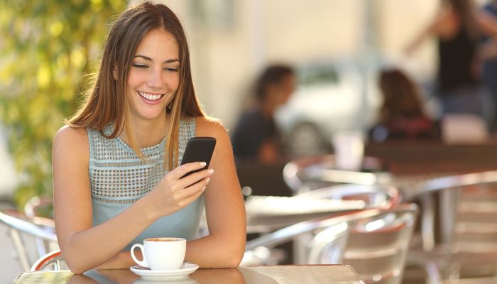 Female business owner conducting her online banking through her phone