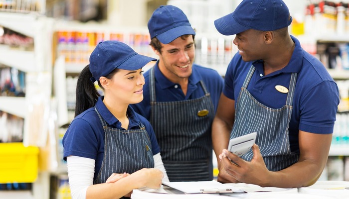 Three happy employees in a hardware store talking