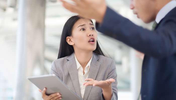 Young businesswoman holding papers talking with a businessman with anger, Boss found a mistake in documentation.