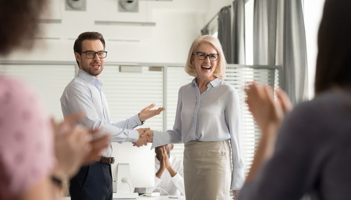 Happy manager boss praising old employee get team appreciation