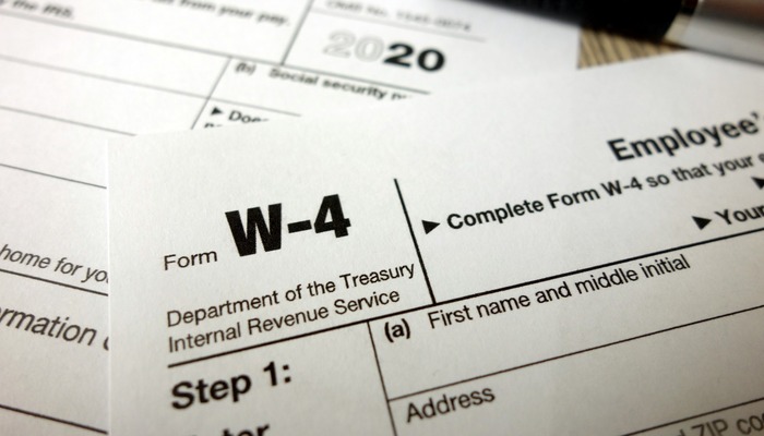 Blank W-4 form and a pen. Tax season