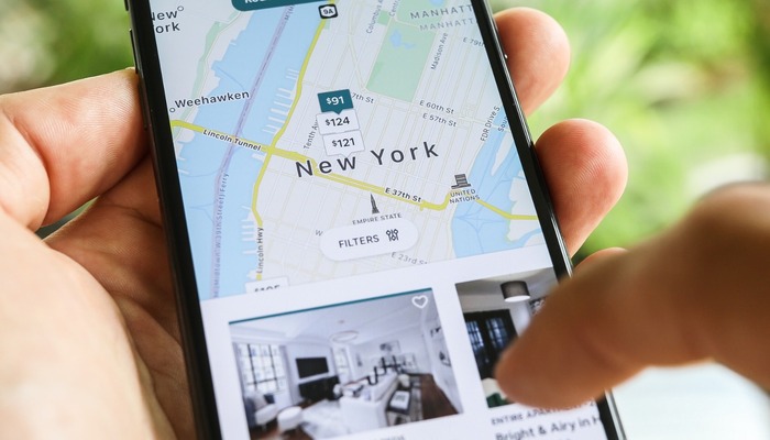 Woman trying to book home apartment room in New York City using Airbnb app